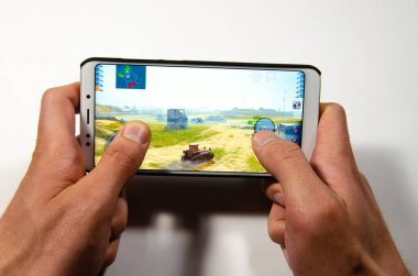 Nisan 2019. San Francisco, ABD. Eller bir akıllı telefon tutarak hangi oyun, Oyunlar Dünya Tankları Blitz oynanışı