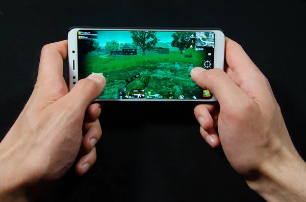 Hands holding a smartphone on which the game, gameplay Gameplay Pubg G Mobile, PlayerUnknown's Battlegrounds — Stock Photo, Image