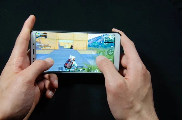 Händer som håller en smartphone där spelet gameplay Pubg G Mobile, Playerunknown ' s Battlegrounds — Stockfoto