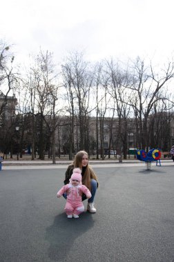 Annem, sokakta küçük bir çocuk, göçebeller, gün boyunca bir ev ile parlak bir oyun alanında oynuyor
