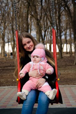 Annem, sokakta küçük bir çocuk, göçebeller, gün boyunca bir ev ile parlak bir oyun alanında oynuyor
