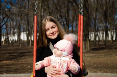 Annem, sokakta küçük bir çocuk, göçebeller, gün boyunca bir ev ile parlak bir oyun alanında oynuyor