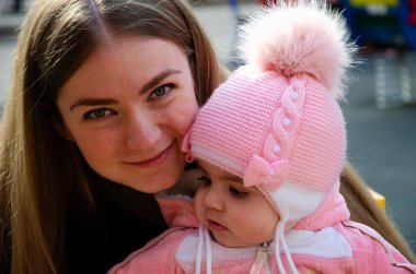 Annem, sokakta küçük bir çocuk, göçebeller, gün boyunca bir ev ile parlak bir oyun alanında oynuyor