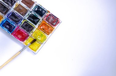Beyaz arka plan üzerindeki boyalar için suluboya ve fırçalı palet. Suluboya boyalar. Fırçalar. Üst ve ön görünüm