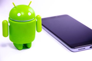 Nisan 2019. Los Angeles, Amerika Birleşik Devletleri. Beyaz bir arka plan ve bir akıllı telefon ile Yeşil plastik Android rakam. Şekil, logo Android, Google