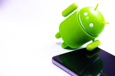 Nisan 2019. Los Angeles, Amerika Birleşik Devletleri. Beyaz bir arka plan ve bir akıllı telefon ile Yeşil plastik Android rakam. Şekil, logo Android, Google