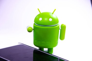 Nisan 2019. Los Angeles, Amerika Birleşik Devletleri. Beyaz bir arka plan ve bir akıllı telefon ile Yeşil plastik Android rakam. Şekil, logo Android, Google