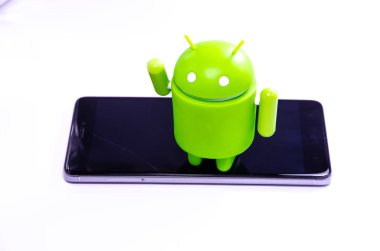 Nisan 2019. Los Angeles, Amerika Birleşik Devletleri. Beyaz bir arka plan ve bir akıllı telefon ile Yeşil plastik Android rakam. Şekil, logo Android, Google