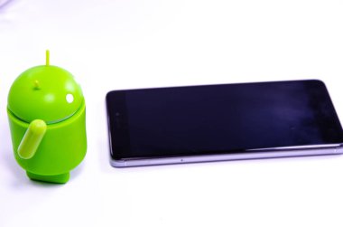 Nisan 2019. Los Angeles, Amerika Birleşik Devletleri. Beyaz bir arka plan ve bir akıllı telefon ile Yeşil plastik Android rakam. Şekil, logo Android, Google