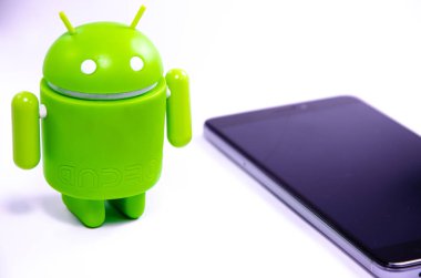 Nisan 2019. Los Angeles, Amerika Birleşik Devletleri. Beyaz bir arka plan ve bir akıllı telefon ile Yeşil plastik Android rakam. Şekil, logo Android, Google