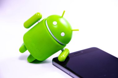 Nisan 2019. Los Angeles, Amerika Birleşik Devletleri. Beyaz bir arka plan ve bir akıllı telefon ile Yeşil plastik Android rakam. Şekil, logo Android, Google