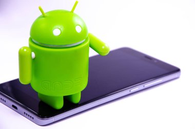 Nisan 2019. Los Angeles, Amerika Birleşik Devletleri. Beyaz bir arka plan ve bir akıllı telefon ile Yeşil plastik Android rakam. Şekil, logo Android, Google