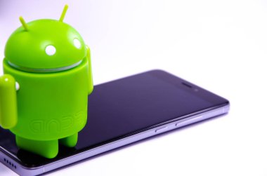 Nisan 2019. Los Angeles, Amerika Birleşik Devletleri. Beyaz bir arka plan ve bir akıllı telefon ile Yeşil plastik Android rakam. Şekil, logo Android, Google