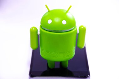 Nisan 2019. Los Angeles, Amerika Birleşik Devletleri. Beyaz bir arka plan ve bir akıllı telefon ile Yeşil plastik Android rakam. Şekil, logo Android, Google