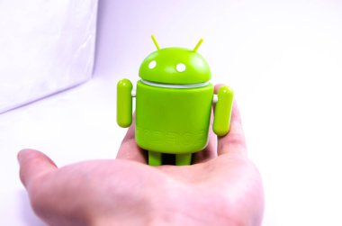 Nisan 2019. Los Angeles, Amerika Birleşik Devletleri. Beyaz bir arka plan ve bir akıllı telefon ile Yeşil plastik Android rakam. Şekil, logo Android, Google