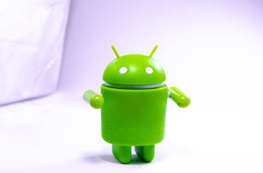 Nisan 2019. Los Angeles, Amerika Birleşik Devletleri. Beyaz bir arka plan ve bir akıllı telefon ile Yeşil plastik Android rakam. Şekil, logo Android, Google