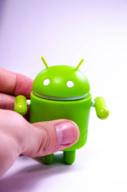 Nisan 2019. Los Angeles, Amerika Birleşik Devletleri. Beyaz bir arka plan ve bir akıllı telefon ile Yeşil plastik Android rakam. Şekil, logo Android, Google