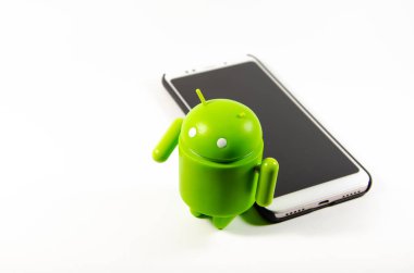 Mayıs 2019. Los Angeles, Amerika Birleşik Devletleri. Beyaz bir arka plan ve bir akıllı telefon ile Yeşil plastik Android rakam. Şekil, logo Android, Google