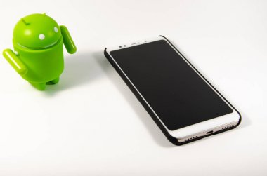 Mayıs 2019. Los Angeles, Amerika Birleşik Devletleri. Beyaz bir arka plan ve bir akıllı telefon ile Yeşil plastik Android rakam. Şekil, logo Android, Google