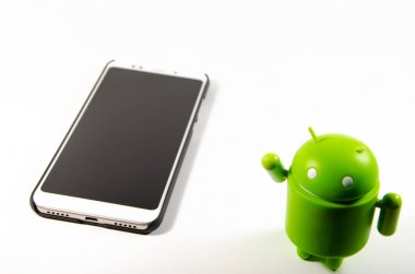 Mayıs 2019. Los Angeles, Amerika Birleşik Devletleri. Beyaz bir arka plan ve bir akıllı telefon ile Yeşil plastik Android rakam. Şekil, logo Android, Google