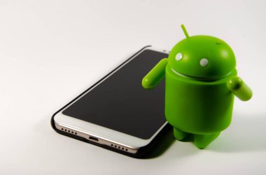 Mayıs 2019. Los Angeles, Amerika Birleşik Devletleri. Beyaz bir arka plan ve bir akıllı telefon ile Yeşil plastik Android rakam. Şekil, logo Android, Google