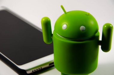 Mayıs 2019. Los Angeles, Amerika Birleşik Devletleri. Beyaz bir arka plan ve bir akıllı telefon ile Yeşil plastik Android rakam. Şekil, logo Android, Google