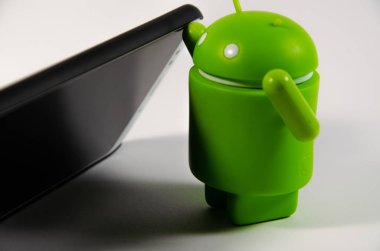 Mayıs 2019. Los Angeles, Amerika Birleşik Devletleri. Beyaz bir arka plan ve bir akıllı telefon ile Yeşil plastik Android rakam. Şekil, logo Android, Google