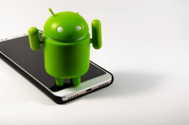 Mayıs 2019. Los Angeles, Amerika Birleşik Devletleri. Beyaz bir arka plan ve bir akıllı telefon ile Yeşil plastik Android rakam. Şekil, logo Android, Google