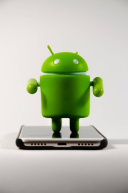 Mayıs 2019. Los Angeles, Amerika Birleşik Devletleri. Beyaz bir arka plan ve bir akıllı telefon ile Yeşil plastik Android rakam. Şekil, logo Android, Google