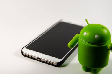 Mayıs 2019. Los Angeles, Amerika Birleşik Devletleri. Beyaz bir arka plan ve bir akıllı telefon ile Yeşil plastik Android rakam. Şekil, logo Android, Google
