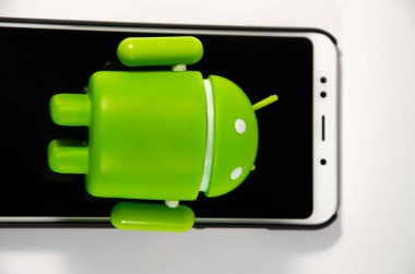 Mayıs 2019. Los Angeles, Amerika Birleşik Devletleri. Beyaz bir arka plan ve bir akıllı telefon ile Yeşil plastik Android rakam. Şekil, logo Android, Google