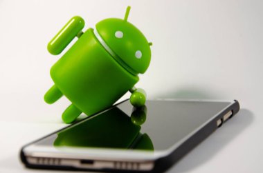 Mayıs 2019. Los Angeles, Amerika Birleşik Devletleri. Beyaz bir arka plan ve bir akıllı telefon ile Yeşil plastik Android rakam. Şekil, logo Android, Google