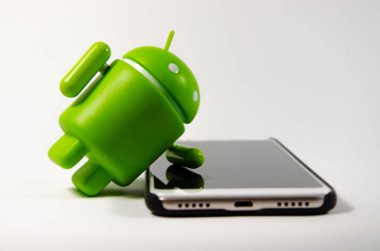 Mayıs 2019. Los Angeles, Amerika Birleşik Devletleri. Beyaz bir arka plan ve bir akıllı telefon ile Yeşil plastik Android rakam. Şekil, logo Android, Google