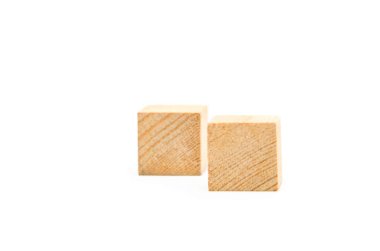 Beyaz arka planda tahta küpler. Birbirinin aynı iki küp yatar, köşegen üzerinde bir sırada durur.