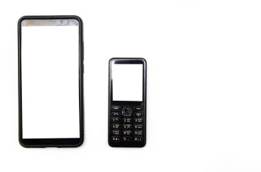 Beyaz ekranlı siyah bir akıllı telefon sol arka planda beyaz ekranlı eski bir cep telefonunun yanında duruyor. Akıllı telefonların evrimi. Metin için doğru yer.