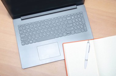 Kanalizasyondaki bir dizüstü bilgisayar bir defter ve kalemdir. İş yeri. Beyaz ekran