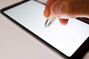 Beyaz arka planda elektronik imza. Akıllı telefona imza attığın için Stylus kalemini erkek eline taktın. Erkek eli makroya elektronik imza atıyor. Büyük yaklaşım.