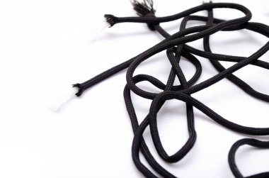 Beyaz arka planda paraşüt. Siyah ipler beyaz arka planda sağda bir yığın halinde duruyor. Dağınık kenarlı paraşüt.