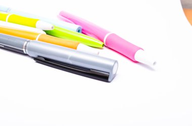 Büyük bir yığın, beyaz arkaplandaki tükenmez kalem sayısı. Beyaz arkaplan üzerine yakın plan yazmak için kalemler