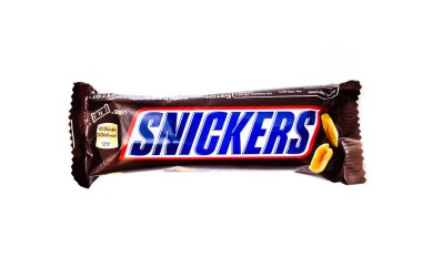 Haziran 2020. Kiev, Ukrayna. Beyaz arka planda küçük bir snickers çikolatası. Makroda fındıklı Snickers. Snickers Pankartı
