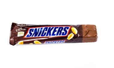 Haziran 2020. Kiev, Ukrayna. 50 gram ağırlığındaki tek bir snickers çubuğu paketten ikiye ayrıldı. Snickers makrodaki fabrika ambalajının yarısı sıkışmış.