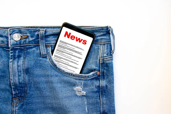 News. Reading the news. The inscription red news on the smartphone screen lies in a jeans pocket. A smartphone with a red inscription news sticks out of a jeans pocket on a white background