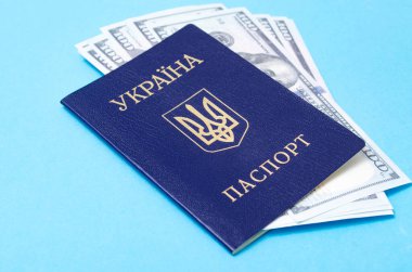Mavi arka planda Ukrayna pasaportu. 100 dolar pasaportun içinde farklı açılardan.
