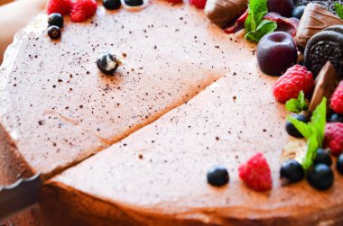 Yukardaki böğürtlenlerden kakaolu pasta, siyah frenk üzümü, bisküvi, yuvarlak tabakta tatlı. Pasta dilimi, makroda böğürtlen. İki numaralı doğum günü pastası. Üst manzara, yan manzara. Yakın plan.