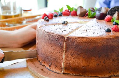 Yukardaki böğürtlenlerden kakaolu pasta, siyah frenk üzümü, bisküvi, yuvarlak tabakta tatlı. Pasta dilimi, makroda böğürtlen. İki numaralı doğum günü pastası. Üst manzara, yan manzara. Yakın plan.