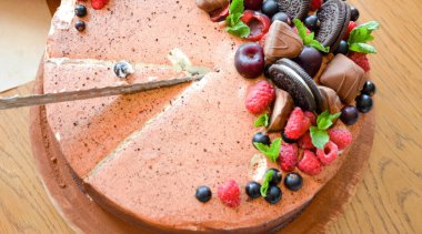 Yukardaki böğürtlenlerden kakaolu pasta, siyah frenk üzümü, bisküvi, yuvarlak tabakta tatlı. Pasta dilimi, makroda böğürtlen. İki numaralı doğum günü pastası. Üst manzara, yan manzara. Yakın plan.