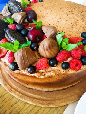 Yukardaki böğürtlenlerden kakaolu pasta, siyah frenk üzümü, bisküvi, yuvarlak tabakta tatlı. Pasta dilimi, makroda böğürtlen. İki numaralı doğum günü pastası. Üst manzara, yan manzara. Yakın plan.