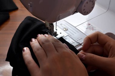 Kendi ellerinle tıbbi siyah bir maske yapıyorsun. DIY koruyucu maskesi. Beyaz arka planda siyah maske. Pamuk maskesi