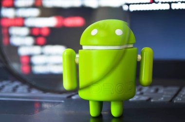 Yeşil bir android figürü programlama ekranında dizüstü bilgisayarın üzerinde duruyor. Büyüteçle bak. Temmuz 2020. Kiev, Ukrayna