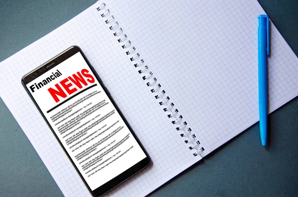 Smartphone Screen Inscription Financial News Lies Next Notebook Pen — Stock Photo, Image